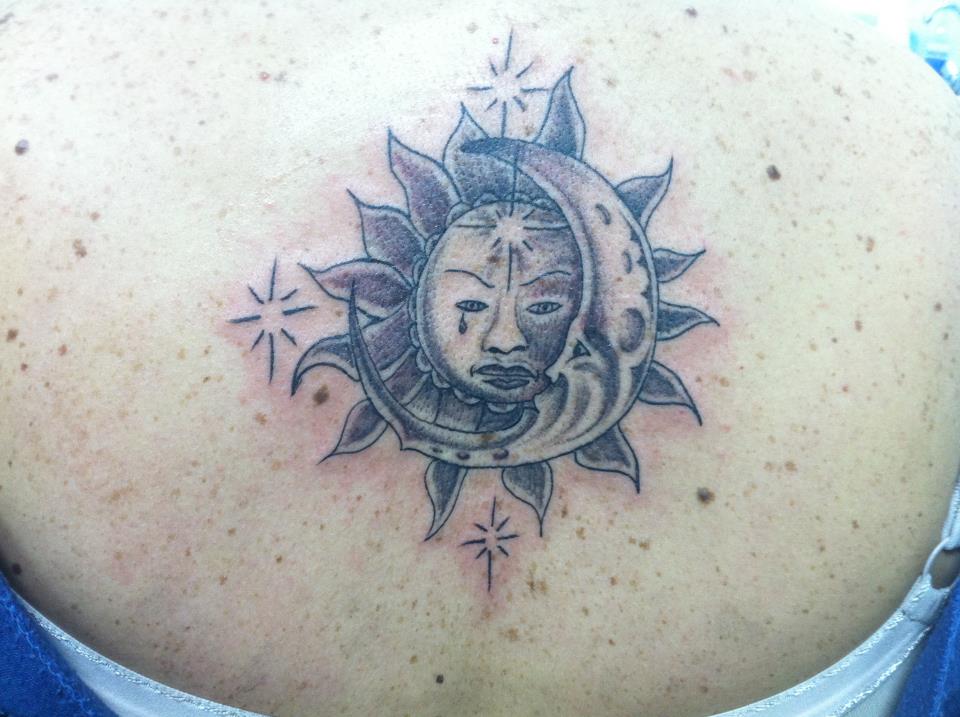 Tatuaje de un sol y una luna con cara
