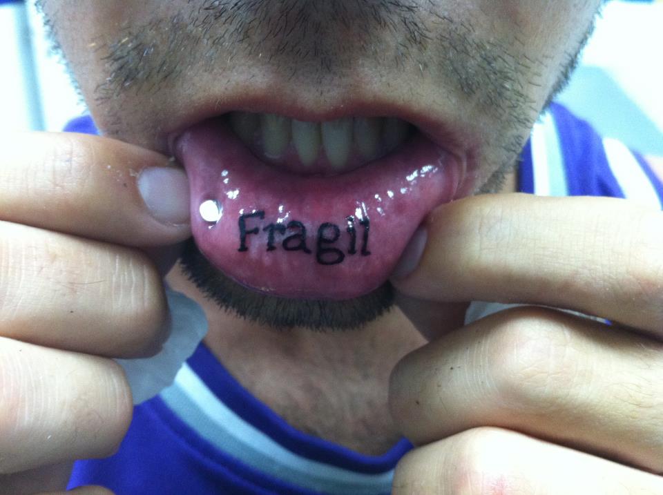 Tatuaje en el labio de la palabra fragil
