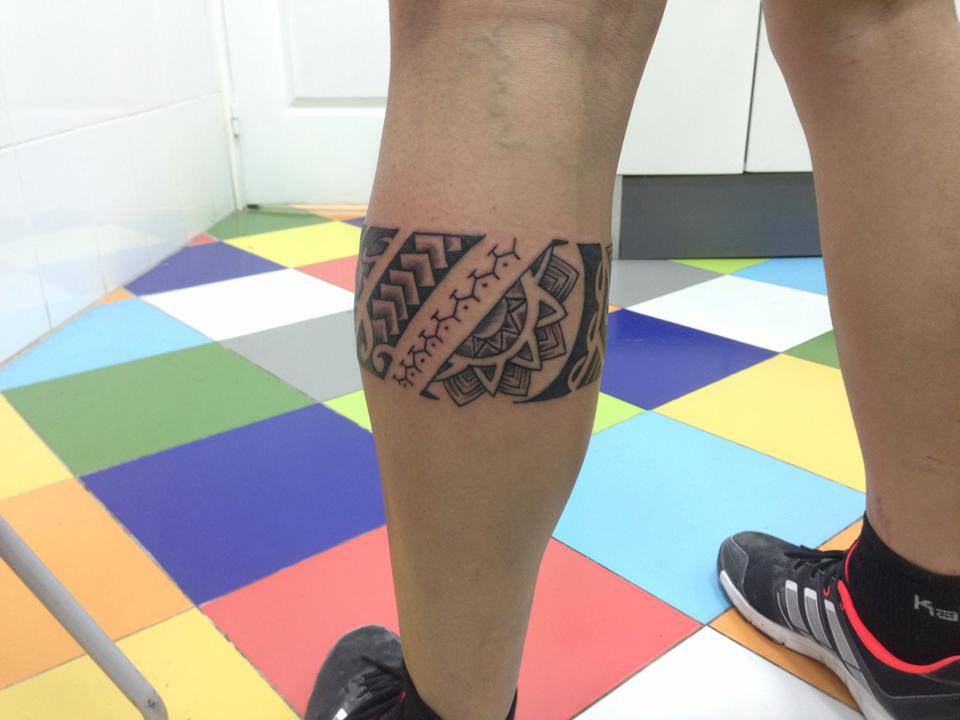 Tatuaje de un brazalete maorí en las piernas