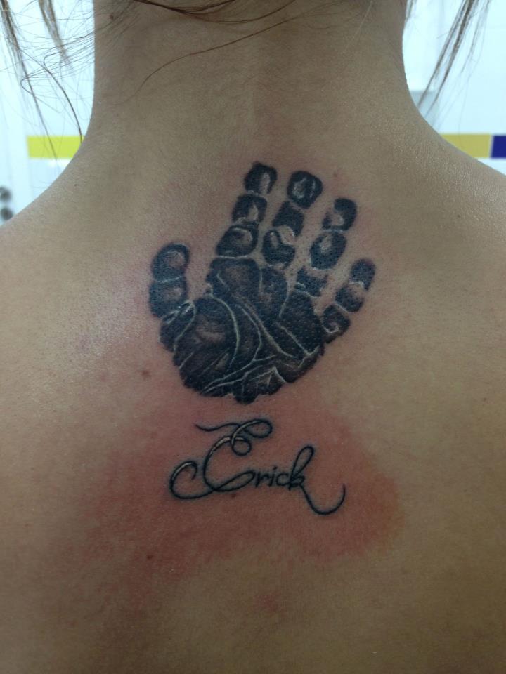 Tatuaje de la marca de una mano en la columna