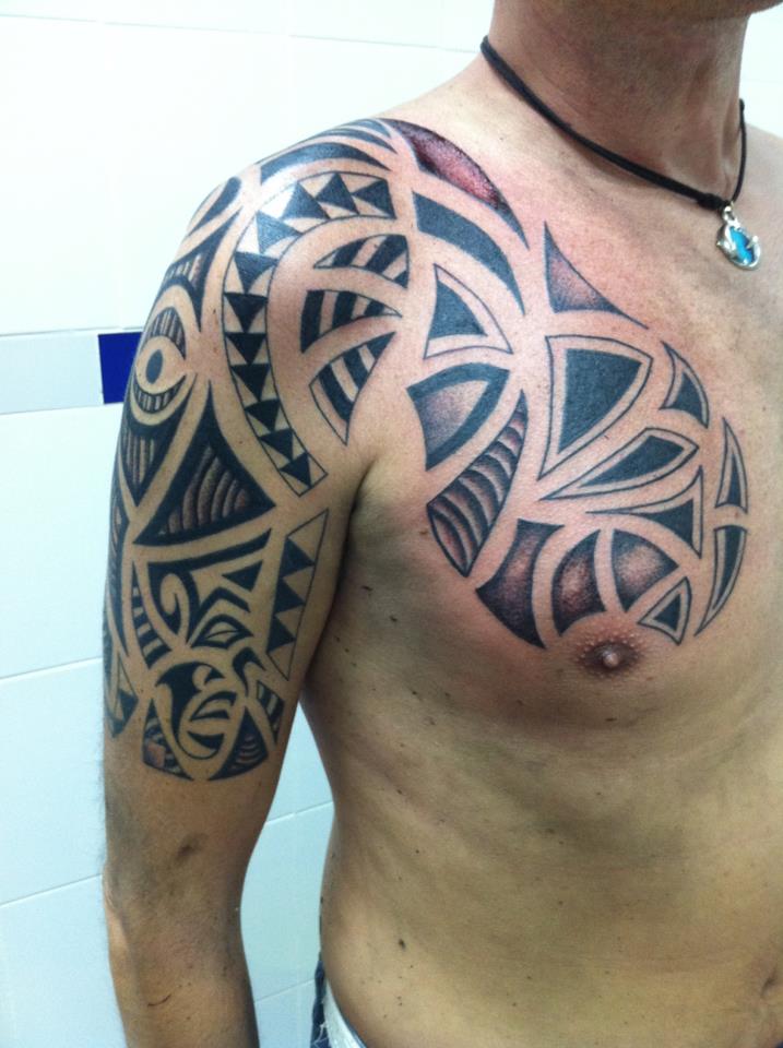 Brazo y pecho tatuado con tribal