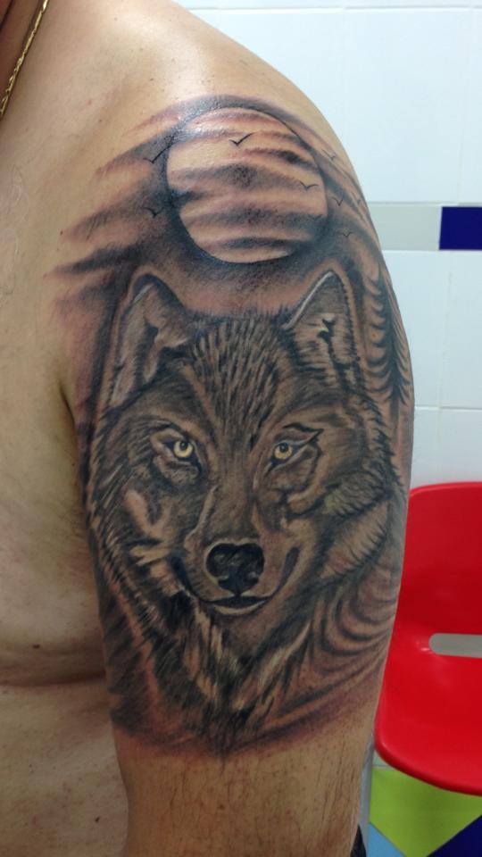 Tatuaje de una cara de lobo bajo la luna llena