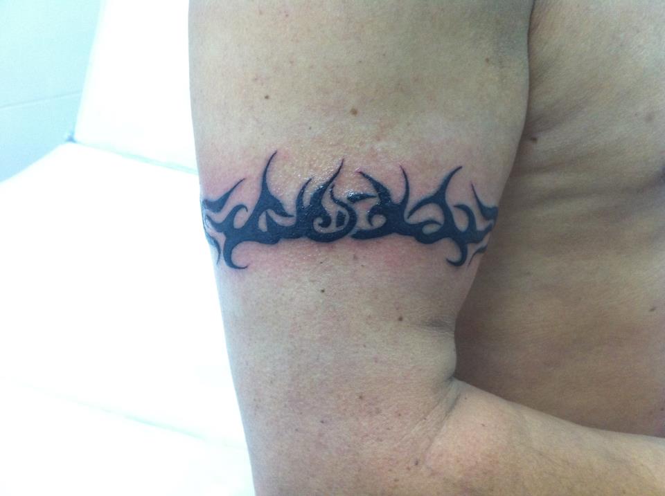 Brazalete tribal tatuado en el brazo