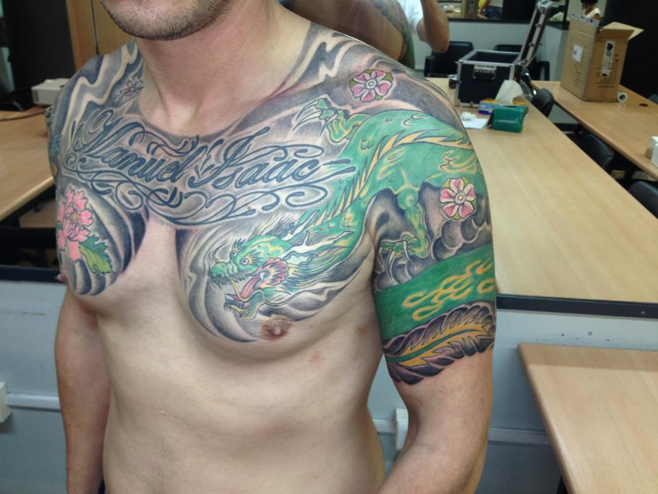 Dragón tatuado en el brazo y pecho