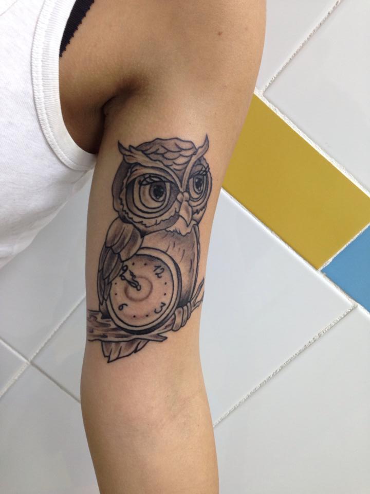 Tatuaje new school de un búho con un reloj