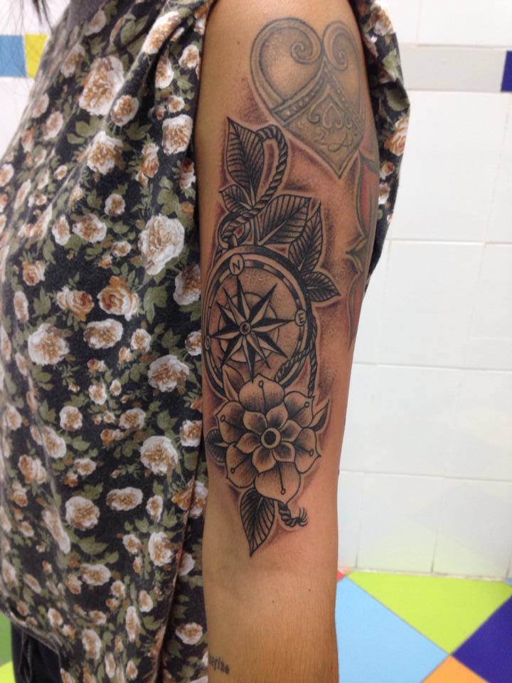 Brújula y una flor, tatuados en el brazo