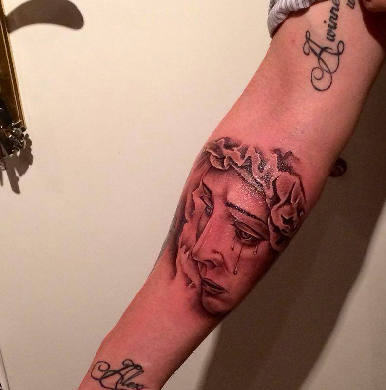 Tatuaje de una virgen llorando en el brazo