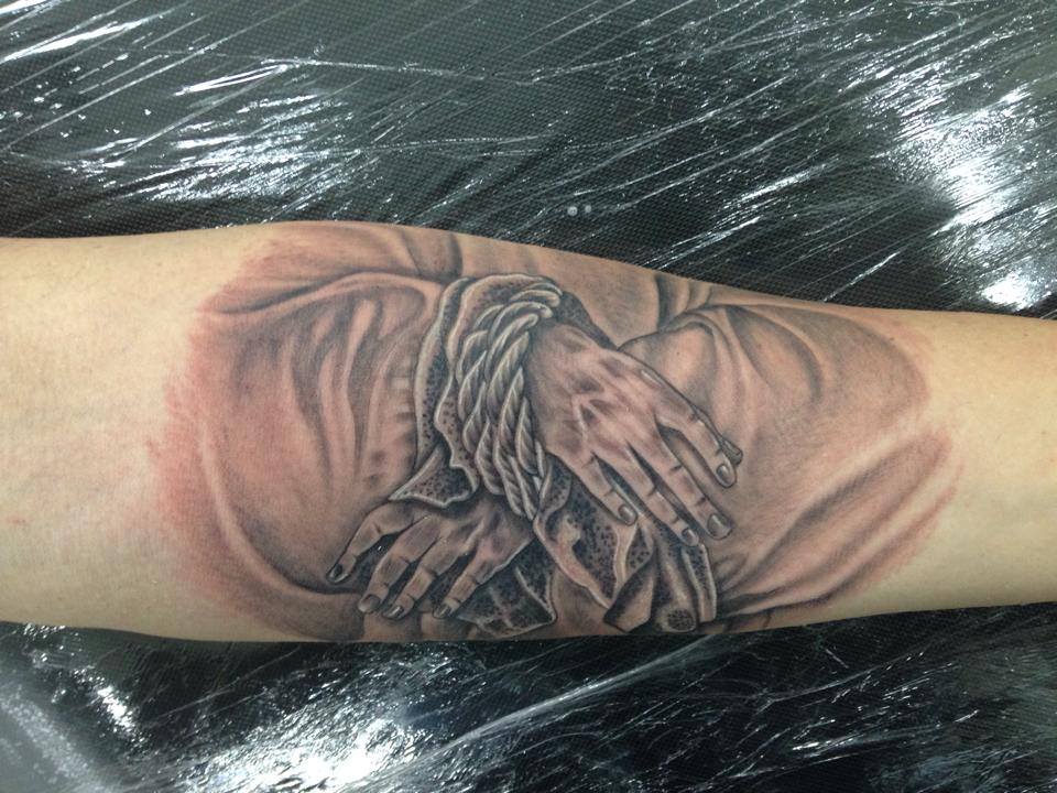 Tatuaje en blanco y negro de unas manos atadas
