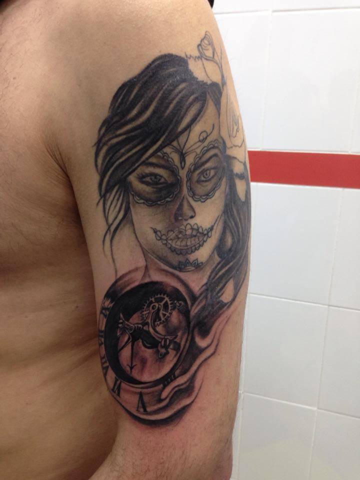 Tatuaje de una chica pintada de calavera mexicana con un reloj abierto