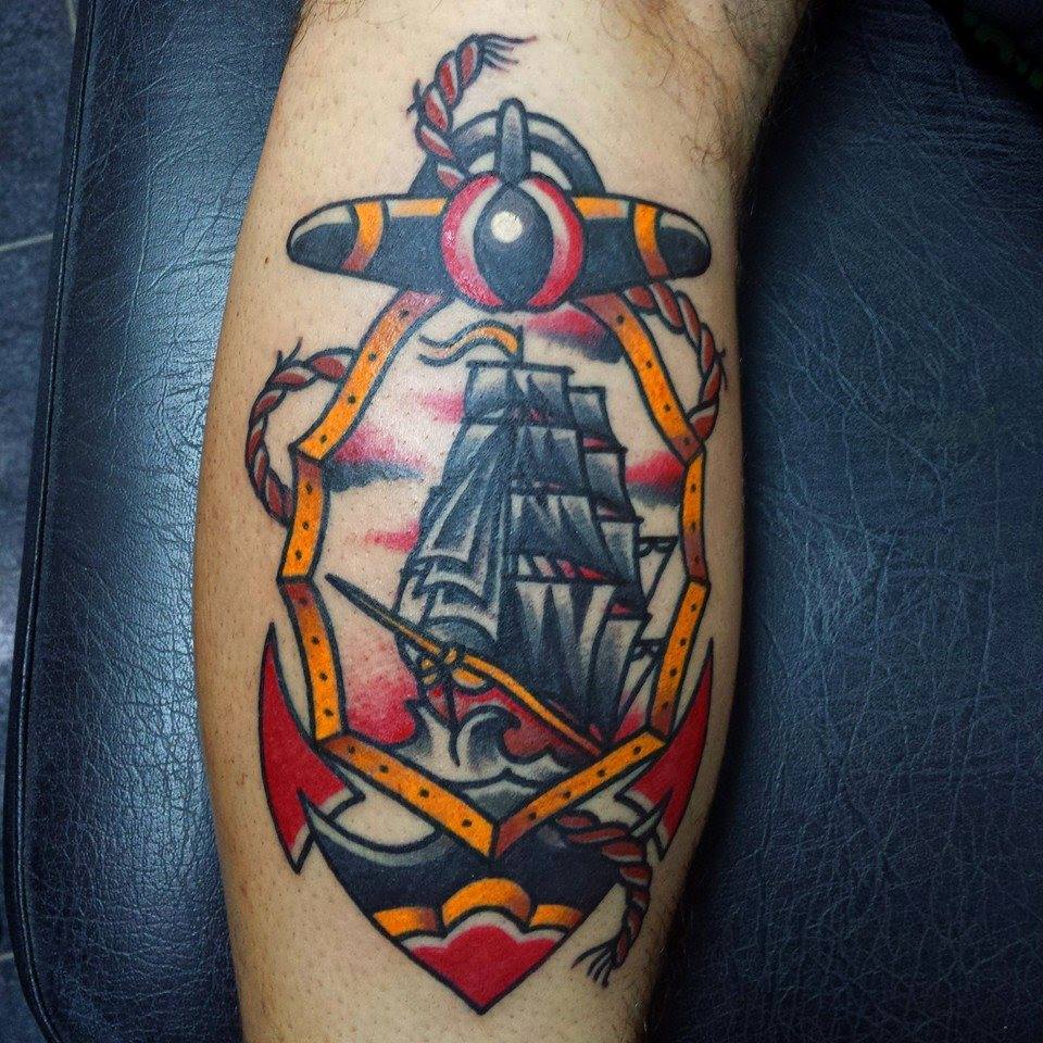 Tatuaje de una ancla con un barco dentro