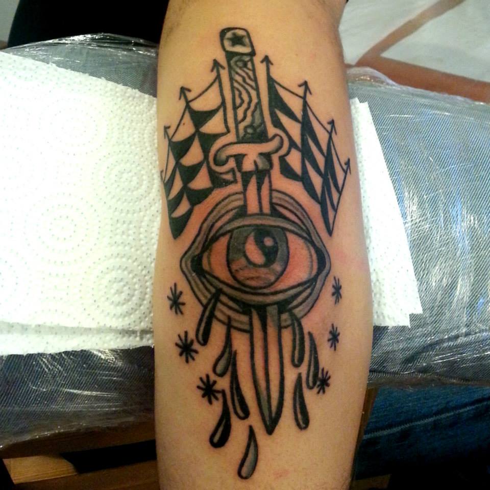 Tatuaje de un ojo atravesado por una espada y telarañas