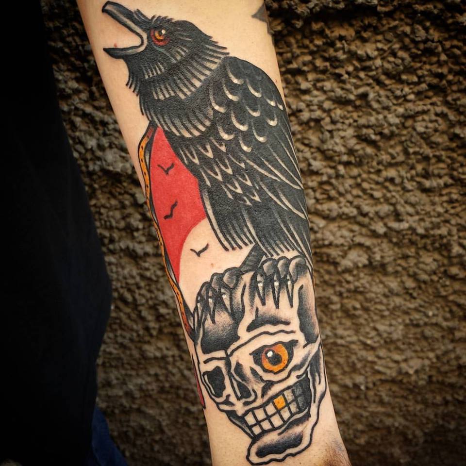 Tatuaje de un cuervo encima de una calavera