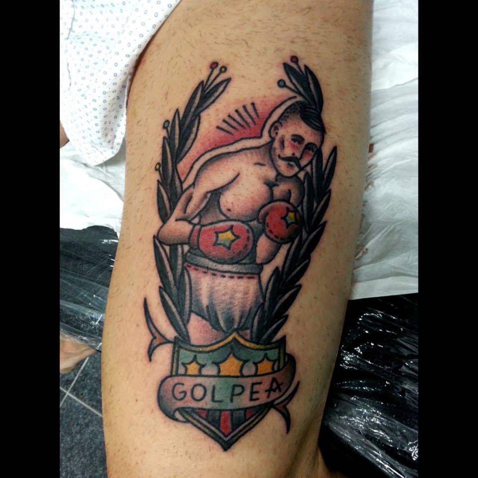 Tatuaje de un boxeado con un escudo y la etiqueta golpea