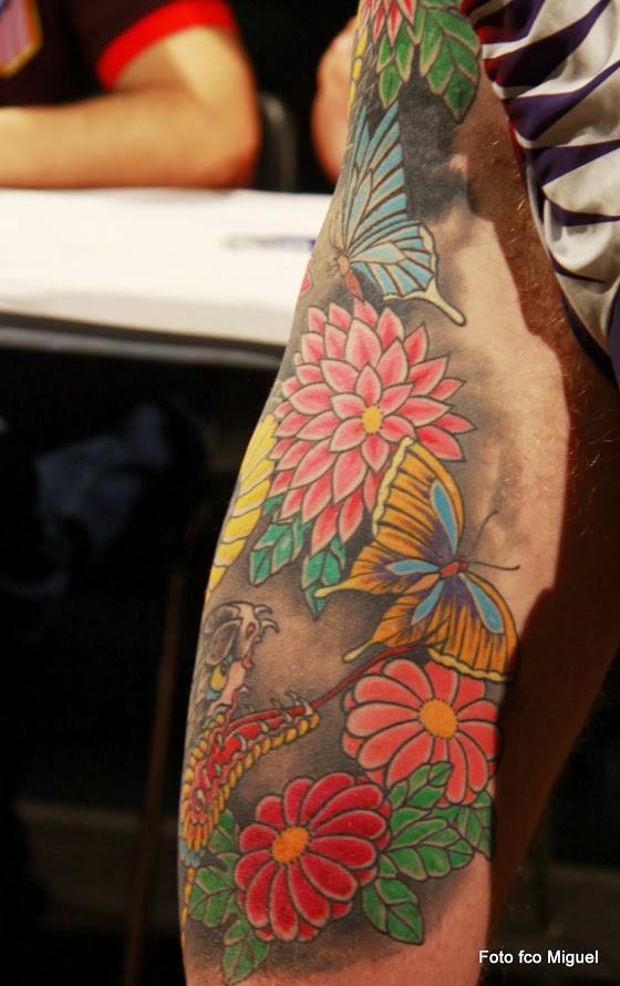 Tatuaje de mariposas y flores con una serpiente