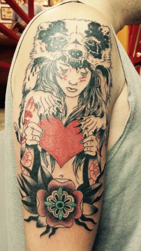 Tatuaje de una chica con una capa de oso, aguantando un corazón