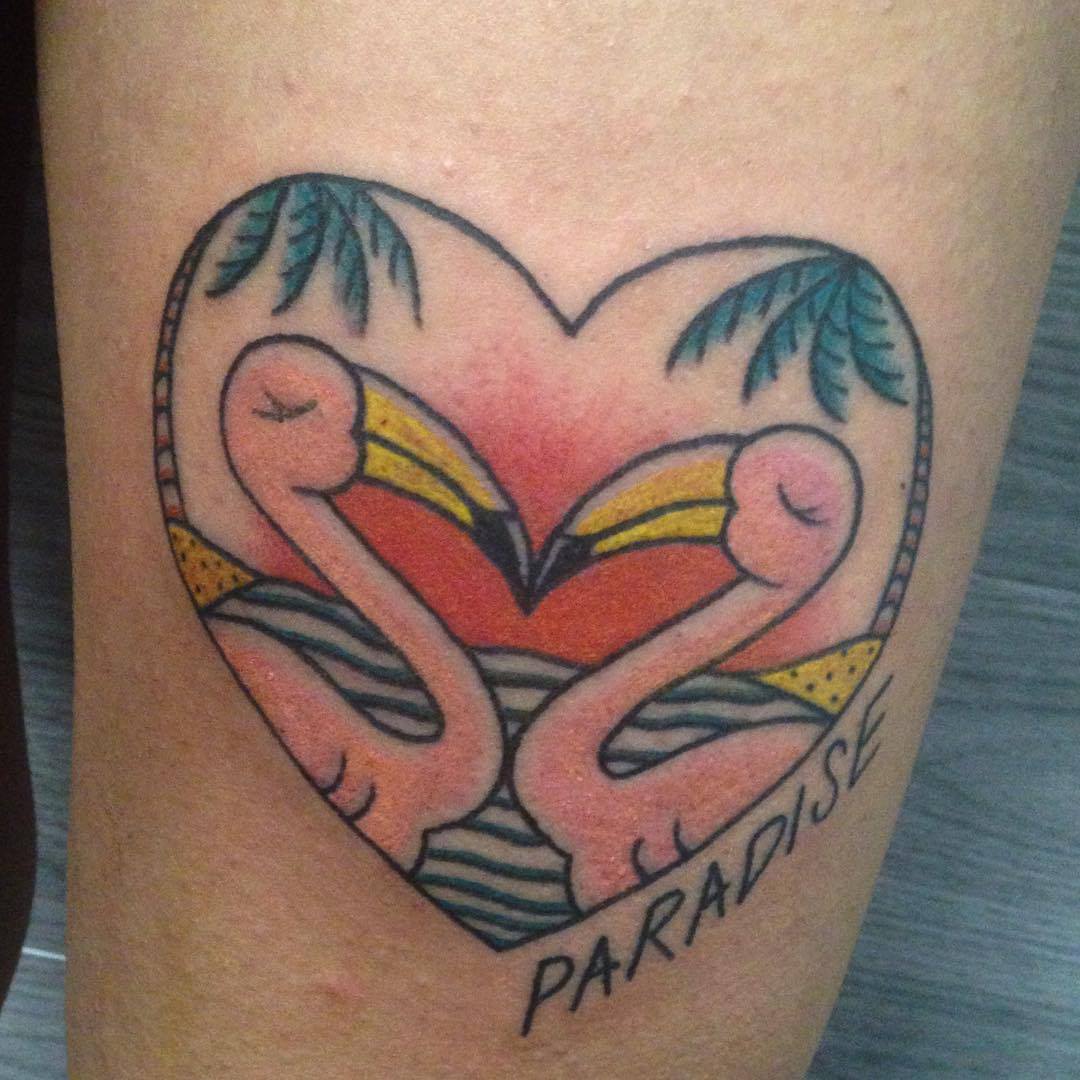 Tatuaje de un corazón con una playa dentro y dos flamencos