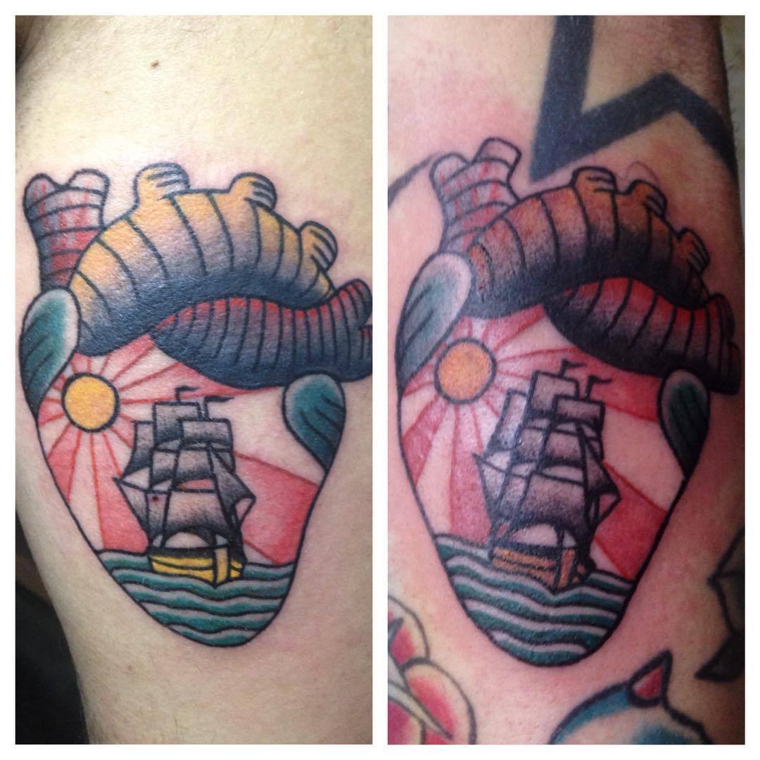 Tatuaje de un corazón con un paisaje y barco dentro