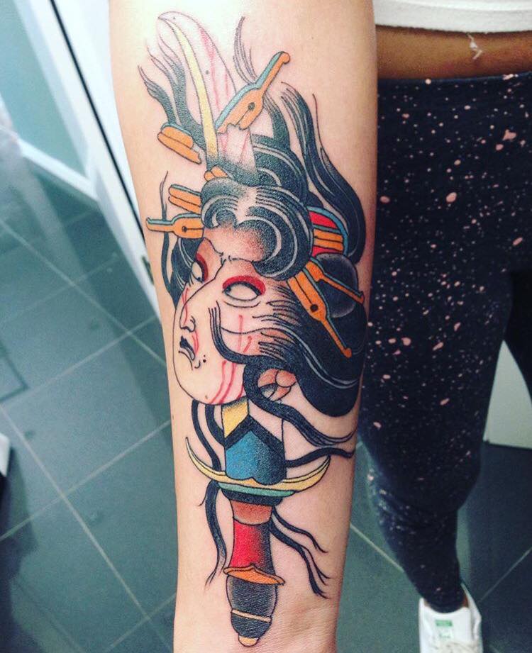 Tatuaje de una cara de samurai atravesada por una espada