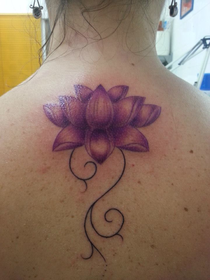 Tatuaje de una flor de loto en la columna