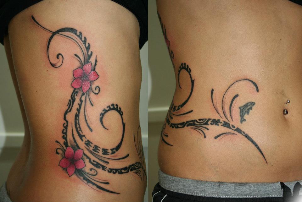 Tatuaje de unas flores con tribales en el costado de una chica