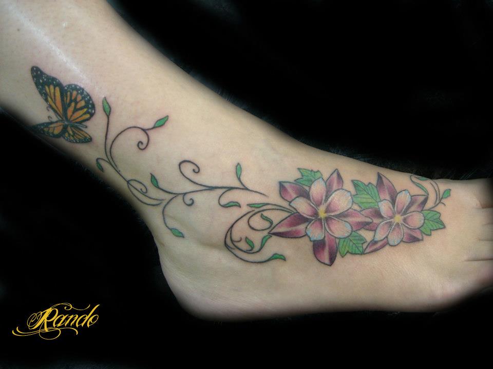 Tatuaje de flores en el pie, con una mariposa volando