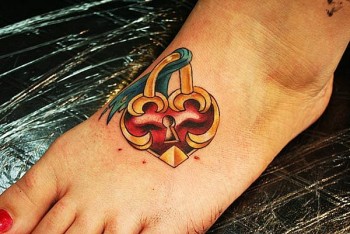Tattoo de corazón con cerrojo en el pie