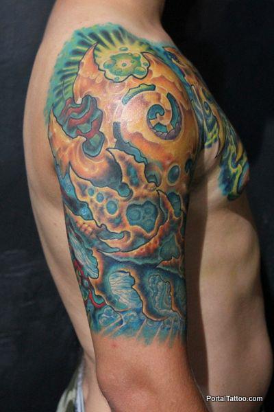 Tattoo de piel alienígena en el brazo, hombro y pecho