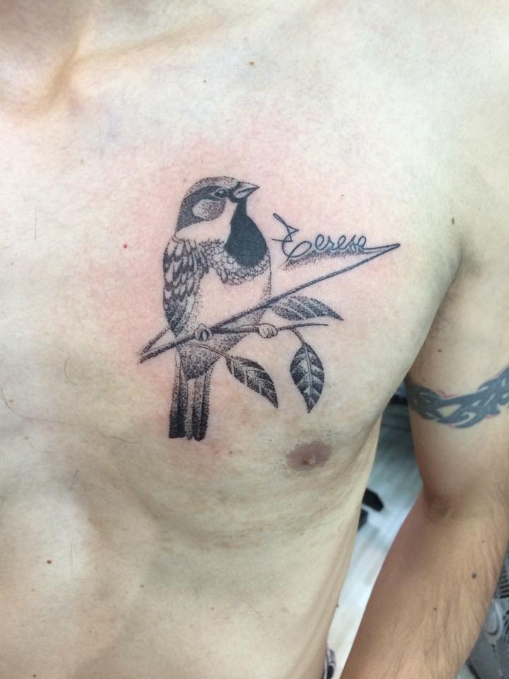 Tattoo blanco y negro de un pájaro en el pecho de un hombre