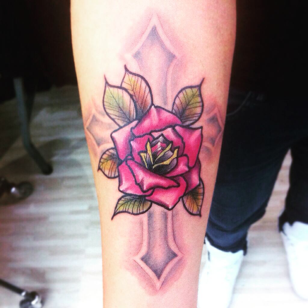 Tattoo de una flor encima de una cruz