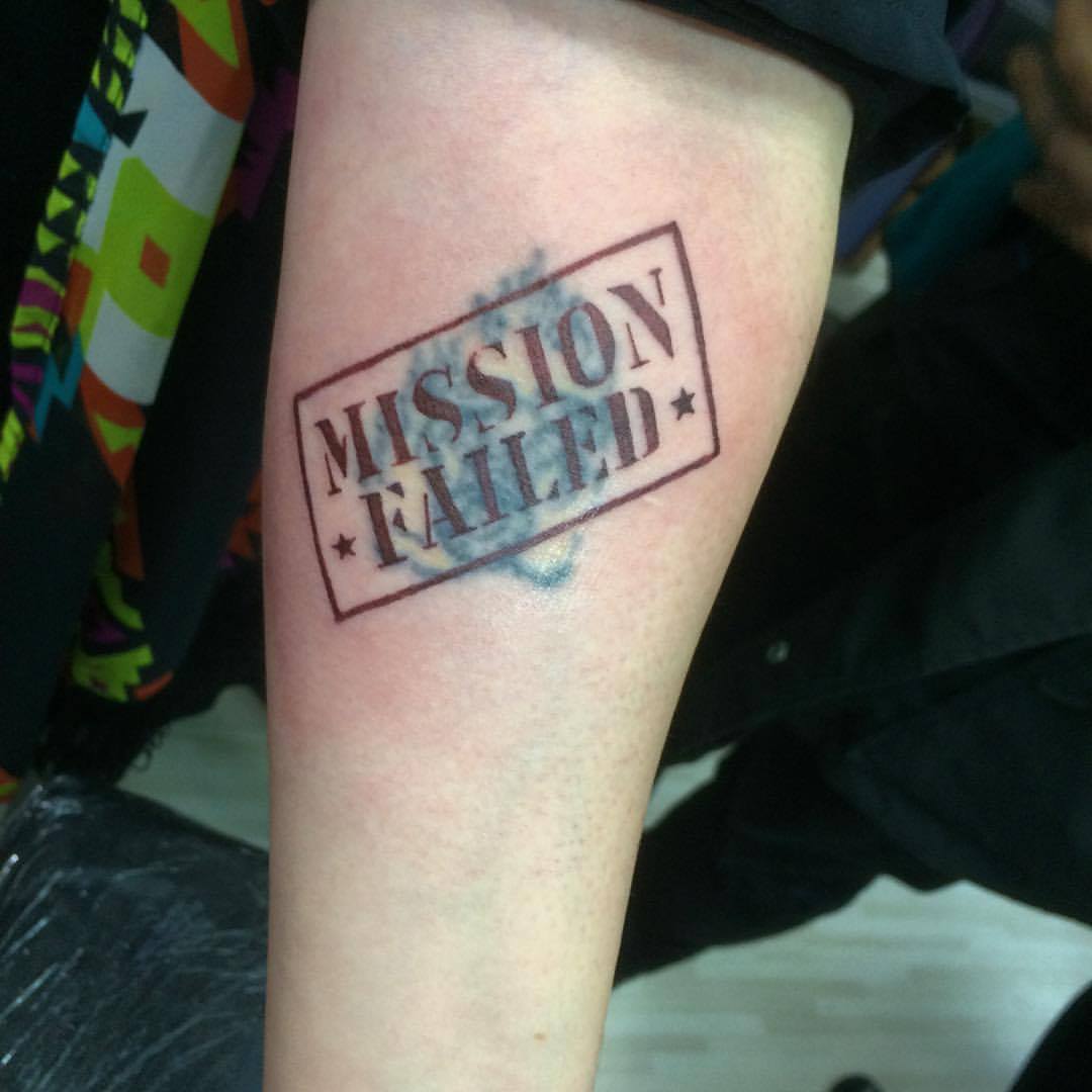 Cover de un tattoo con un cartel que dice Mission Failed