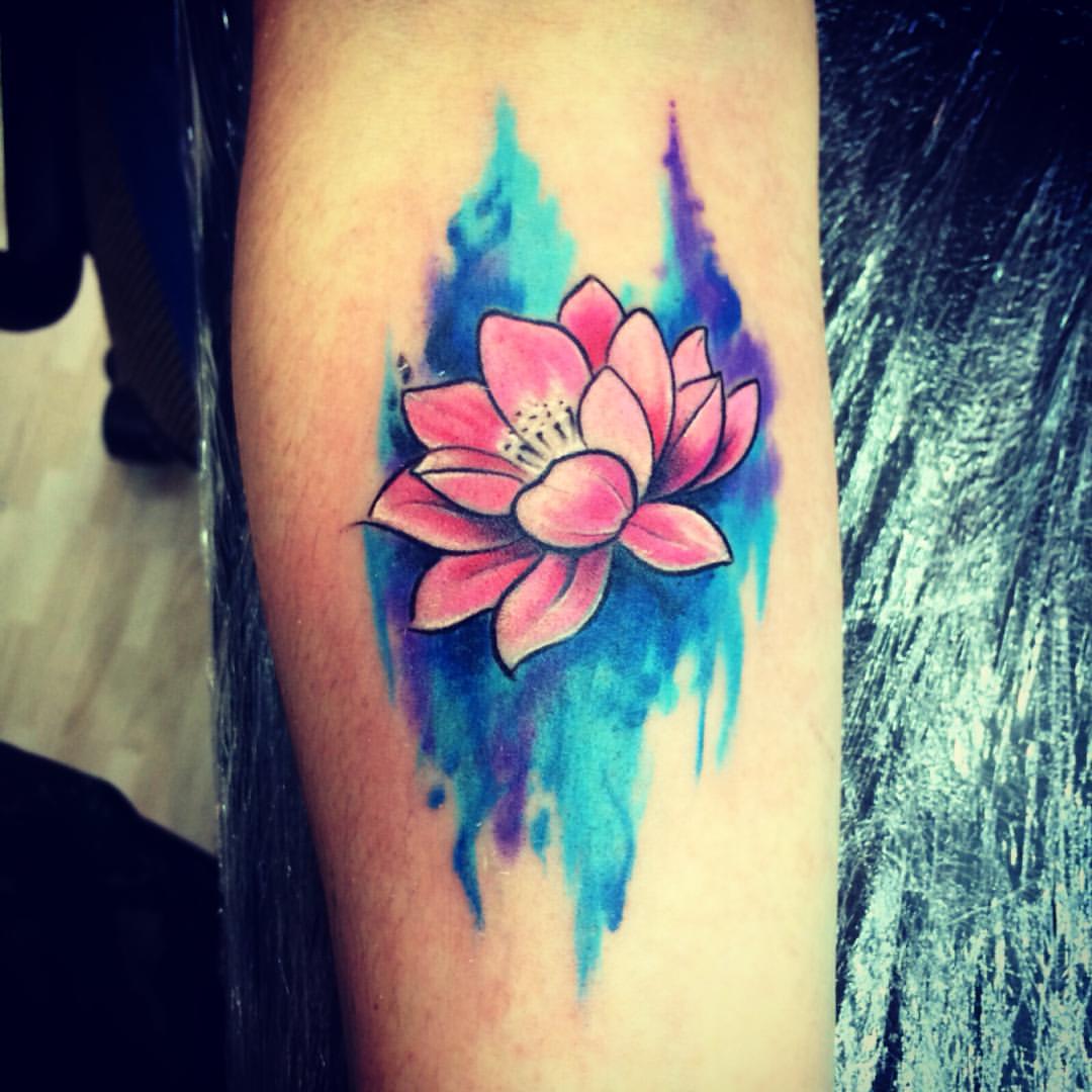 Tattoo de un loto con una mancha de pintura por fondo