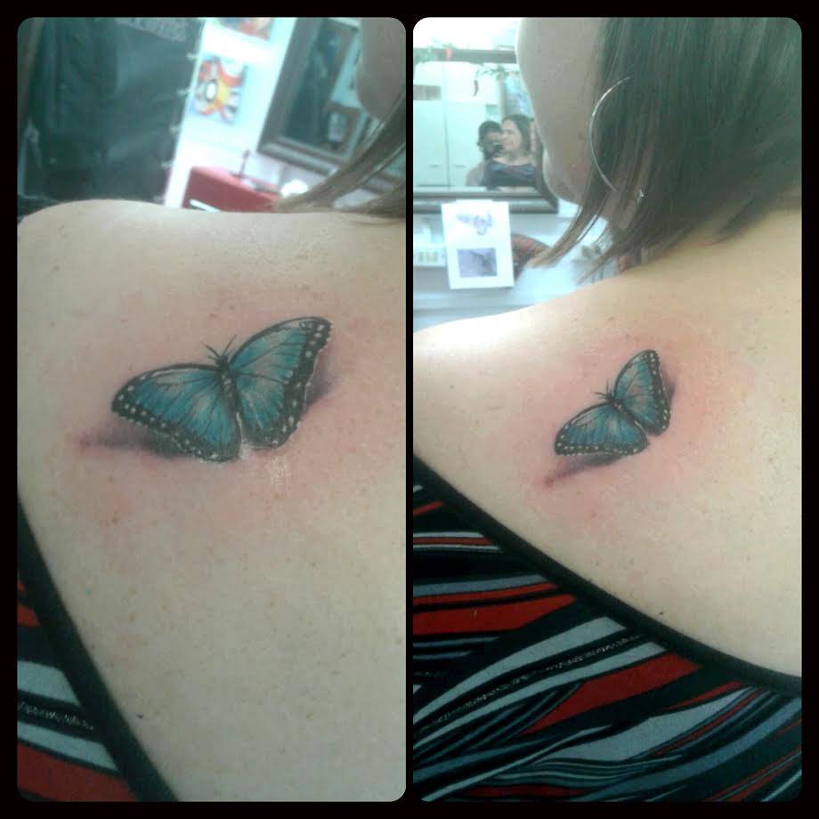 Tattoo de una mariposa posada en la espalda de una chica