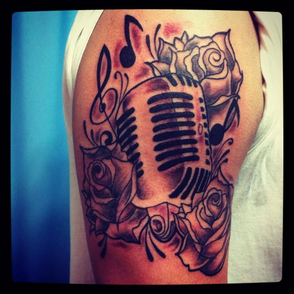 Tattoo de un micrófono entre flores