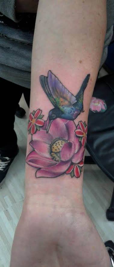 Tattoo de un colibrí volando hacia una flor