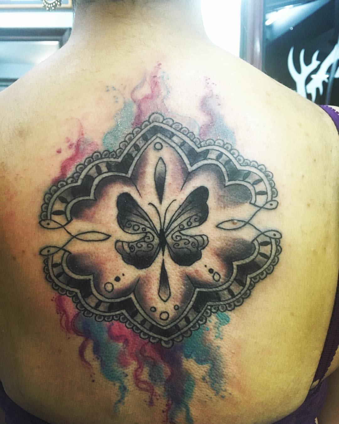 Tattoo de una mariposa en la espalda de una chica