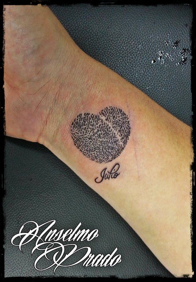 Tattoo de un corazón hecho con dos huellas dactilares y un nombre