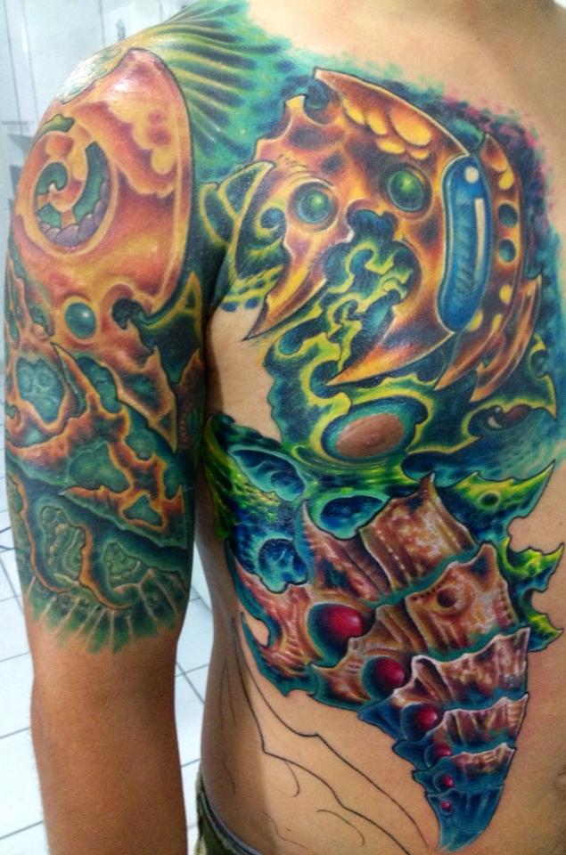 Tattoo biomecánico futuristo en brazo pecho y costado de un hombre