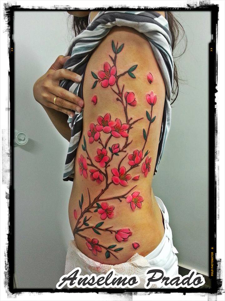 Tattoo de una rama florida en el costado de una chica