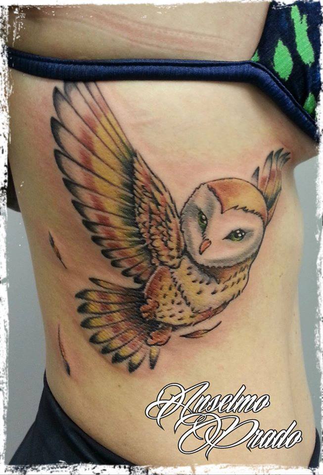 Tattoo de una lechuza volando en las costillas de una chica