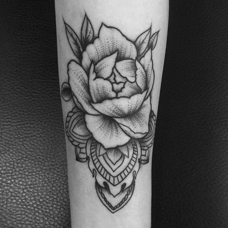 Tattoo de una flor en blanco y negro encima de un mandala