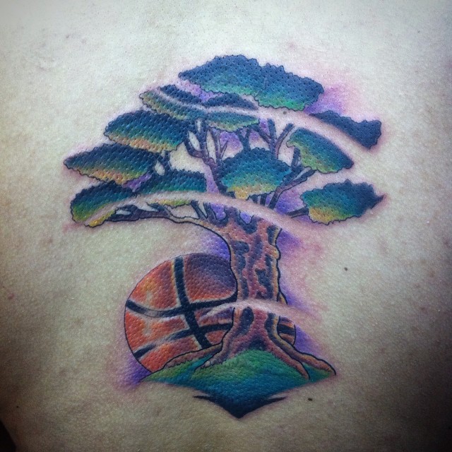 Tattoo de un árbol con una pelota de baloncesto detrás