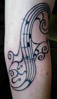 Tatuaje de un pentagrama y unas notas musicales en el brazo