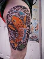 Tatuaje de carpa japonesa, con olas, en el muslo