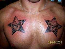 Tatuaje de dos estrellas cadavéricas en el pecho.