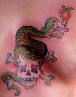 Tatuaje de una serpiente en busca de comerse una manzana encima de una calavera