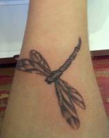 Tatuaje de una libélula en el antebrazo