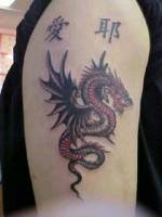 Tatuaje de un dragón alado junto con unos kanjis