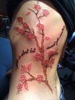 Tatuaje de árbol floreciente en el costado