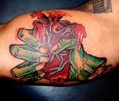 Tatuaje de mano estrujando corazón