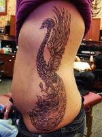 Tatuaje de un ave fenix en el costado